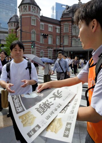  ＪＲ東京駅前で行われた号外の街頭配布（７月31日、読売新聞社提供）